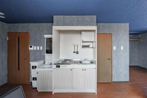a kitchen with white cabinets and a sink at Silk Court 402 in Chitose