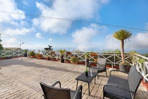 a patio with chairs and a table and palm trees at Casa Andrea in Tacoronte