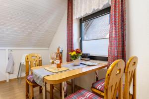a dining room with a table and chairs and a window at Ferienwohnung Luri in Gangelt