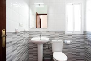 a bathroom with a toilet and a sink and a mirror at Casa Paqui 3 in Roche +15 photos