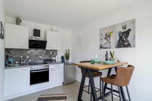 a kitchen with white cabinets and a wooden table at Landtraum 17 in Wittenhofen