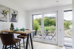 a dining room with a table and a sliding glass door at Landtraum 17 in Wittenhofen +13 photos