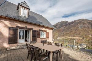 ein Tisch und Stühle auf einer Terrasse mit einem Haus in der Unterkunft Gary Vallée in Sazos
