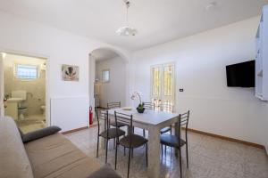 a living room and dining room with a table and chairs at Villa Aurea Retreat Lux in Porto Cesareo