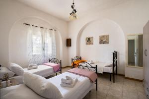 a room with three beds and a couch at Villa Aurea Retreat Lux in Porto Cesareo