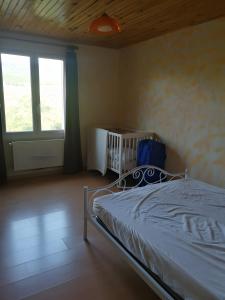 a bedroom with a bed and a window and a crib at Gîte À La Campagne in Bourdeaux