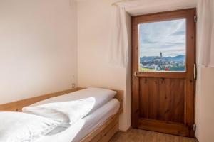 two beds in a room with a window and a door at App Schlern - Gasser in Vols am Schlern