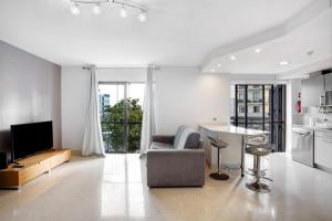 a living room with a couch and a table and a kitchen at Apartamento Forum View in Funchal