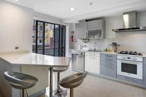 a kitchen with a counter and stools in it at Apartamento Forum View in Funchal