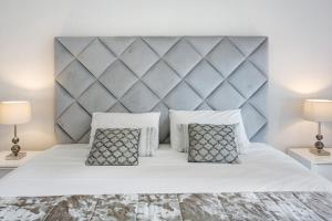 a bedroom with a large white bed with two lamps at Apartamento Forum View in Funchal