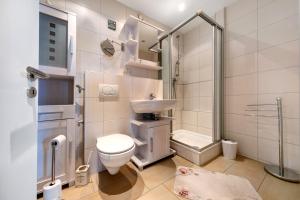 a bathroom with a toilet and a sink and a shower at Apartment Ankerplatz in Bremerhaven +18 photos