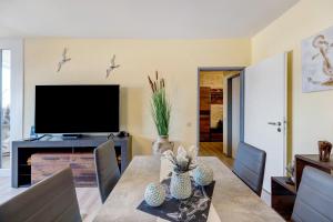 a dining room with a table and a television at Apartment Ankerplatz in Bremerhaven