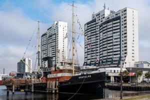 a ship docked in a harbor with tall buildings at Apartment Ankerplatz in Bremerhaven