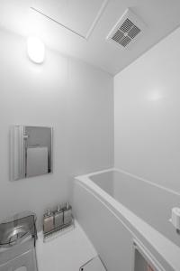 a white kitchen with a sink and a mirror at Silk Court 402 in Chitose