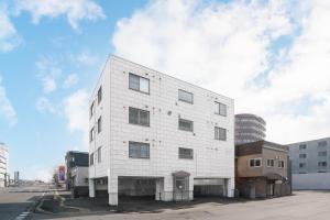 a white building on the side of a street at Silk Court 402 in Chitose