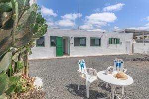 two chairs and a table in front of a building at Apartamentos Callao in Playa Quemada