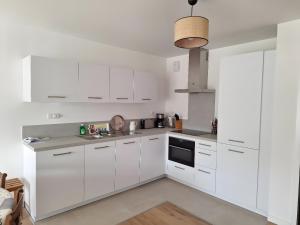 a white kitchen with white cabinets and a sink at Résidence Oscar Wilde entrée A in Neufchâtel-Hardelot