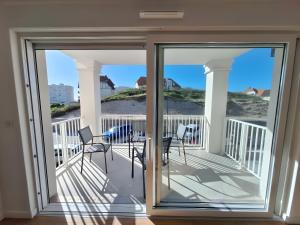 a balcony with chairs and a view of the beach at Résidence Oscar Wilde entrée A in Neufchâtel-Hardelot +5 photos