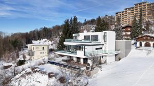 a large white house in the snow with buildings at Apartment Himmelweit in Freyung