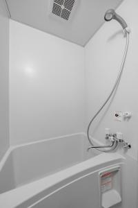 a bathroom with a bath tub with a shower head at Silk Court 402 in Chitose