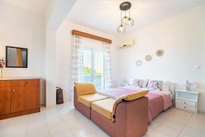 a bedroom with a bed and a couch and a window at La Christine in Rhodes Town