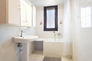 a white bathroom with a sink and a shower at La Christine in Rhodes Town