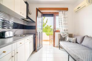 a kitchen with white cabinets and a couch in a room at La Christine in Rhodes Town +16 photos