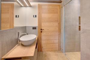 a bathroom with a white bowl on a wooden counter next to a door at Aria di Casa Piazzi in Valdisotto +19 photos