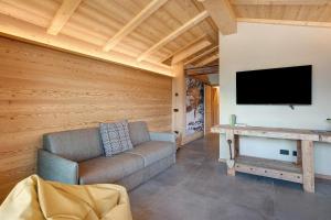 a living room with a couch and a flat screen tv at Aria di Casa Piazzi in Valdisotto