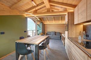 a kitchen and dining room with a table and chairs at Aria di Casa Piazzi in Valdisotto