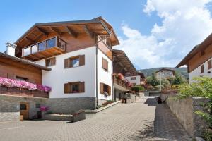 a house with a wooden roof on a street at Aria di Casa Piazzi in Valdisotto