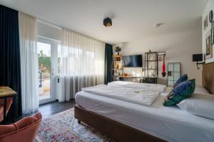 a bedroom with a large bed and a large window at Flora und Fauna by Kamelu in Gengenbach