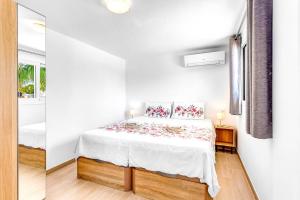 a white bedroom with a bed and a mirror at Studio Torreblanca close to beach in Fuengirola +10 photos