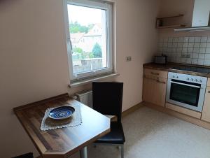 a small kitchen with a wooden table and a window at Zirbelkiefer 8 in Bad Klosterlausnitz