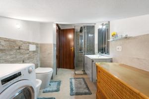 a bathroom with a toilet and a washer and dryer at Casa Eleonora in San Sperate +16 photos