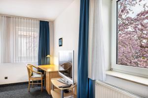 a hotel room with a desk and a window at Gasthaus, Hotel am Dreienberg in Friedewald