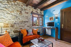 a living room with a stone wall at Teixo in Vega de Logares
