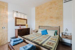 a bedroom with a bed and a brick wall at Casa Roberta in Granitola