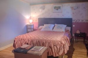 a bedroom with a large bed with pink walls at Logis des Tilleuls in Saint-Mathieu