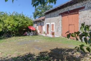 an external view of a stone house with a yard at Logis des Tilleuls in Saint-Mathieu