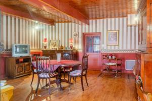 a dining room with a table and chairs and a tv at Logis des Tilleuls in Saint-Mathieu
