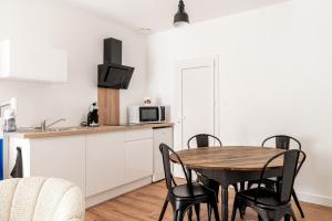 a kitchen and dining room with a table and chairs at L'écrin De La Sèvre in Cugand