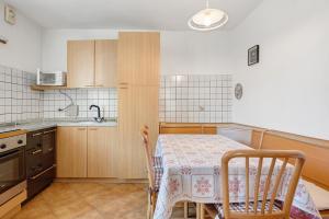 a kitchen with a table and a table and chairs at Casa Mariotta in Castello di Fiemme