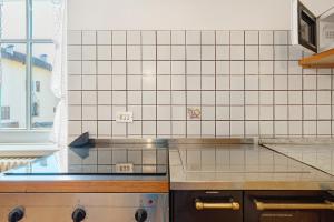 a kitchen with white tiled walls and a counter top at Casa Mariotta in Castello di Fiemme +29 photos