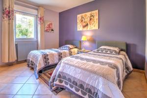 two beds in a room with purple walls at Maison de vacances proche de Sarlat in Carsac-Aillac