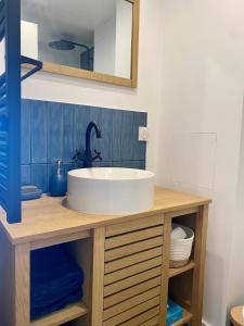 a bathroom with a white sink and a mirror at Vue Mer Et Jardin in Théoule-sur-Mer