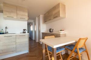 a kitchen with wooden cabinets and a table and chairs at Vue Mer Et Jardin in Théoule-sur-Mer