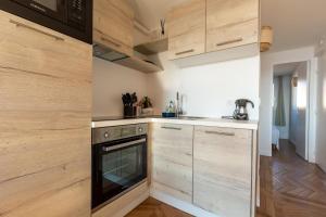 a kitchen with wooden cabinets and a stove at Vue Mer Et Jardin in Théoule-sur-Mer