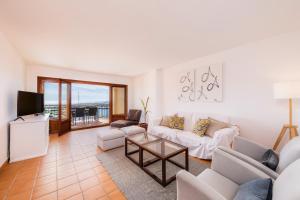 a living room with a couch and a tv at Es Port in Cala Ratjada