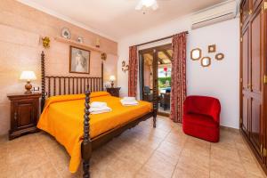 a bedroom with a bed and a red chair at Casa Toni in Portocolom +20 photos